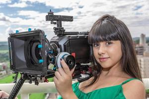 mujer joven operando cámara de cine foto