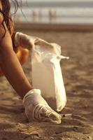 Cleaning up cigarette butts on the beach. photo