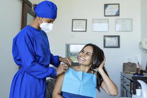 paciente mujer sonríe y mira a su dentista. foto