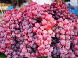 uvas rojas frescas a la venta en el mercado foto