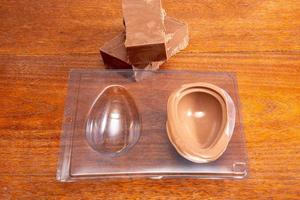 Homemade Easter egg factory. Making eggshell from easter egg with melted chocolate and a shape. photo