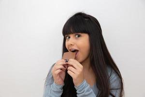 mujer joven comiendo chocolate foto