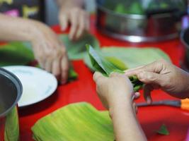 Woman doing Stuffed Dough Pyramid Dessert Stuffed Dough Pyramid year cake Chinese New Year cake, dessert Made glutinous rice banana leave basket cook photo