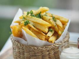 French fries, Potato chips Yellow crispy fries in wooden basket, snack delicious photo