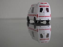 modelo de emergencia de ambulancia coche de color blanco en el reflejo de la mesa del espejo foto