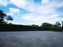 Parking lot sprinkled with gravel on tree bush nature background photo