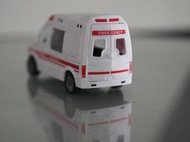 modelo de emergencia de ambulancia coche de color blanco en el reflejo de la mesa del espejo foto
