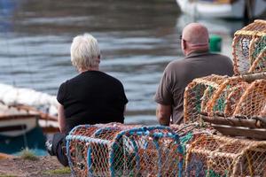 Dunbar, Escocia, Reino Unido, 2010. Dos personas sentadas en el muelle foto