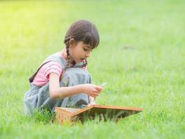 las niñas recolectan materiales naturales y aprenden fuera de la escuela foto