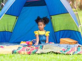 A cute girl is sitting with a toy in a tent photo