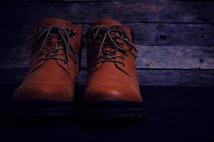 Brown, laced boots on an old wooden, rustic background. photo