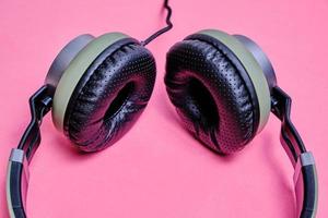 Wired headphones in khaki on a pink background. photo