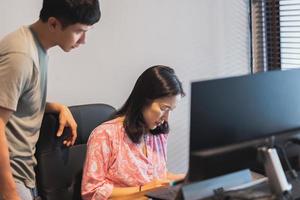 Freelance couple working from home at desk with desktop computer on table. photo