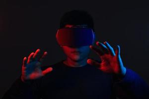 Young man wearing VR goggles. Metaverse technology virtual reality concept. Virtual Reality Device, Simulation, 3D, AR, VR, Innovation and Technology of the Future on Social Media. photo