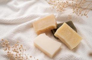 Handmade soap bars on white towel top view with copy space photo