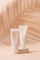 maqueta de tubo de crema para presentación de marca. producto de belleza natural para el cuidado de la piel en un podio blanco cuadrado. colores tierra naturales