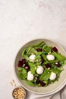 Beetroot, mozzarella and arugula salad with pine nuts top view