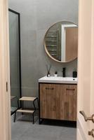 gran espejo sobre el lavabo del recipiente en el elegante interior del baño foto