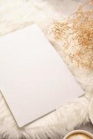 blank calendar mockup with carrot cake dessert, coffee and flowers on white rug photo