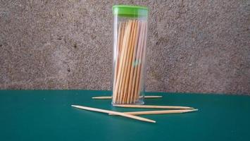 a collection of toothpicks inside and outside the container photo