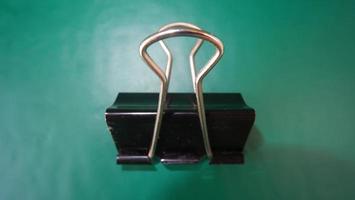 photo black paperclip on green background