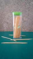 a collection of toothpicks inside and outside the container photo