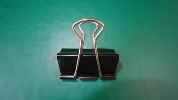 photo black paperclip on green background