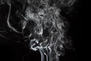 Smoke isolated on black background. Movement of white smoke photo