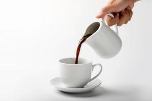 Verter una taza de café sobre fondo blanco. foto