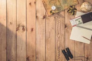 Overhead view of Traveler's accessories Essential vacation items, and Different objects on wooden background. Travel concept background photo