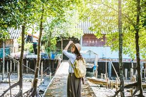 mujer asiática viaja a pie por la naturaleza y observa la forma de vida de los aldeanos en los pueblos rurales pescadores. turismo, verano, lago, vacaciones, viajar tailandia. mochila, naturaleza, viaje, vacaciones foto