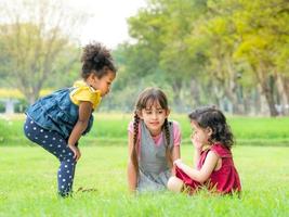 un grupo de niños pequeños de muchas nacionalidades juegan y aprenden fuera de la escuela foto