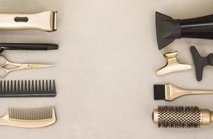 Hairdressing tools on a gray background. Frame of hair salon items, scissors, clips, Curling iron, combs, hair dryer. Centered space for text. photo