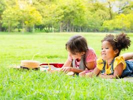 un grupo de niños pequeños de muchas nacionalidades juegan y aprenden fuera de la escuela foto