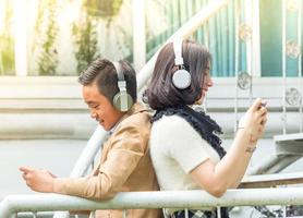 niño y niña juegan y escuchan música en sus teléfonos móviles foto