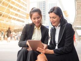 Caucasian and Asian business woman happy and smiling after successful to find her business data photo