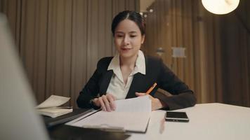 Hardworking business woman in formal working suit enjoy working, happy positive environment in the office, laptop and papers at office desk, data analysis management, online video conference meeting