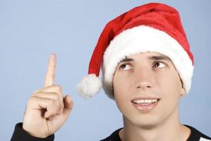Young Christmas man pointing up photo