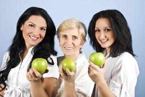 tres mujeres de belleza saludable que te dan manzanas foto