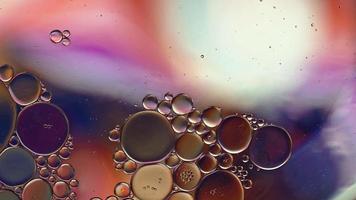 abstrakt färgglad matolja droppar bubblor och sfärer som flyter på vattenytan, makrovideografi video