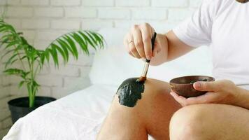 Man applying medical treatment mud on his injured knee, healthy joints
