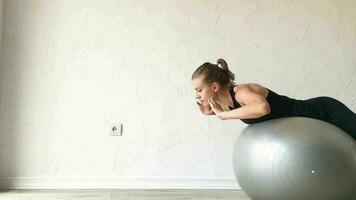 fitness, sport och hälsosam livsstil. ung kvinna tränar hemma med stabilitet boll eller fitness boll. hemmaträning video