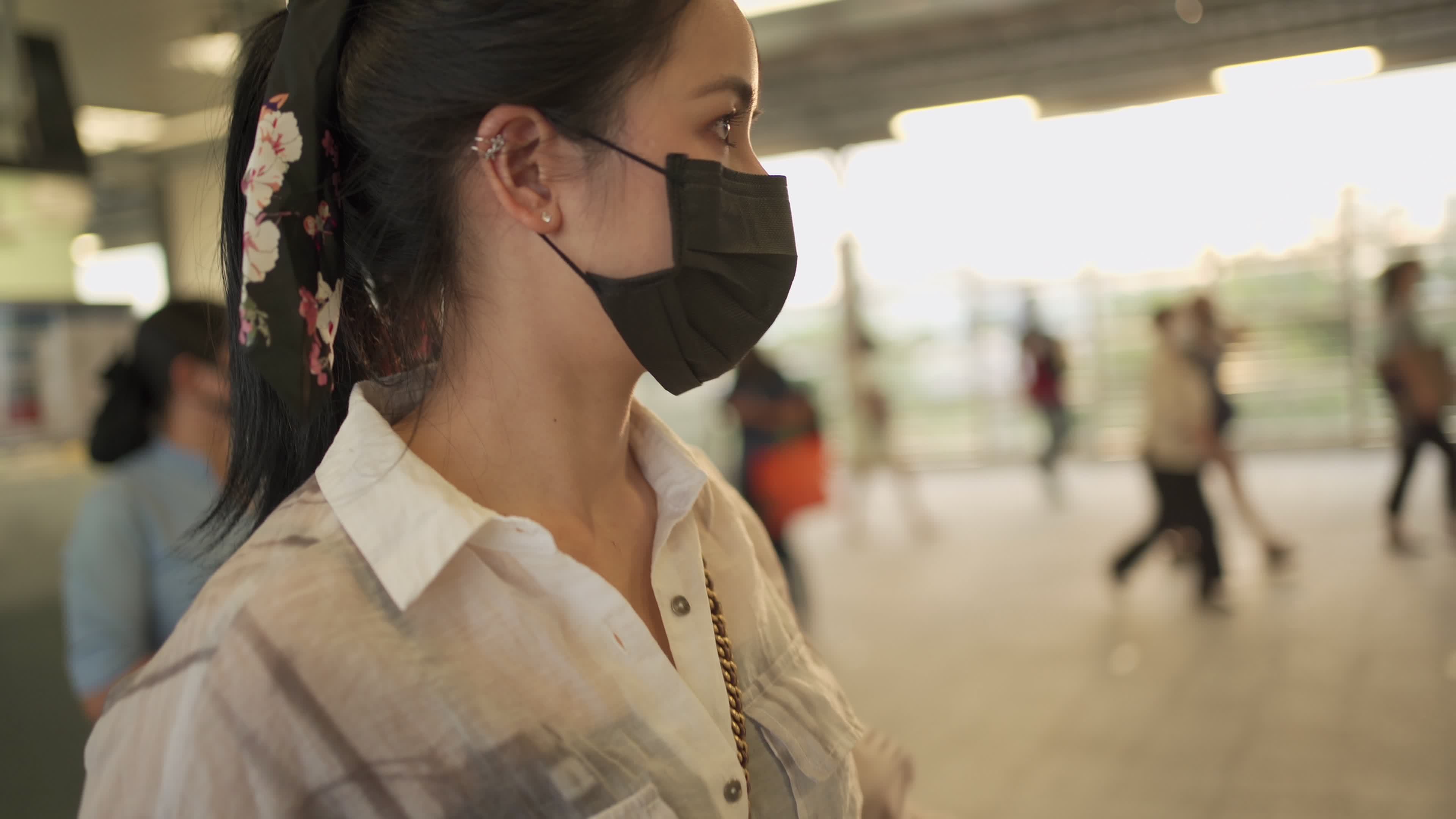 Young Asian woman wear protective mask inside metro strain station. covid-19 lady wait for friends, rush hour self prevention on public healthcare, golden sunset hour 7469117 Stock Video at