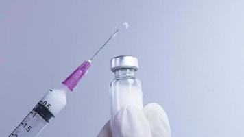 close-up shot van een melkachtig wit vaccin dat uit de spuit stroomt, medisch behandelingsserum of medicijn, moderne biotechnologie om mensenlevens te redden, coronavirus of mrna-vaccin, verzwakken of doden virus video