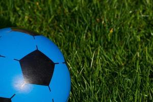 blue plastic football against green grass background photo