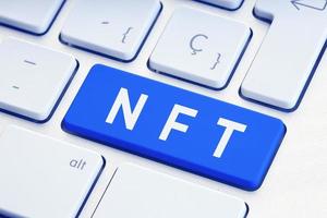 NFT or Non Fungible Token text on blue computer Keyboard Key photo