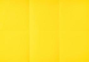 Yellow crumpled unfolded paper sheet texture background. Paper folded in six. Full frame photo