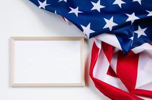 bandera americana y marco vacío para texto sobre fondo blanco. cultura de estados unidos. concepto de independencia, día conmemorativo o día del trabajo. foto