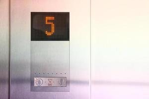 La pantalla LCD muestra el número del quinto piso en un ascensor de metal foto