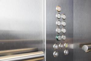 botones y pasamanos en ascensor de metal foto